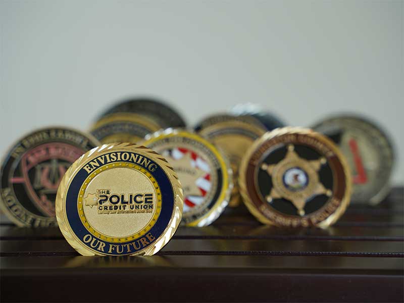 A photo of challenge coins, including The Police Credit Union's coin